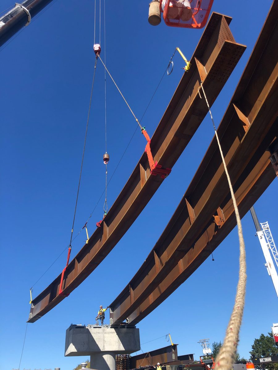 Curved steel girders lifted into place by crane